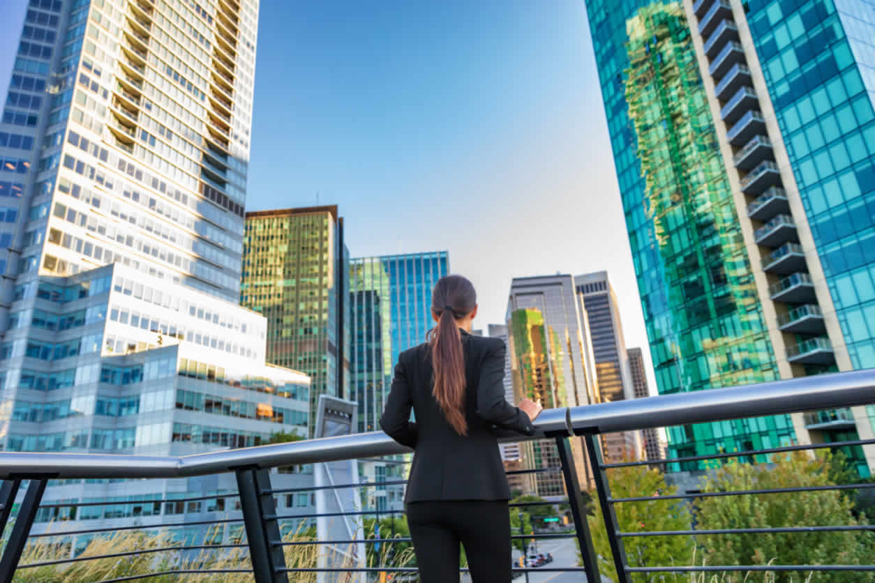 Business woman looking at office buildings