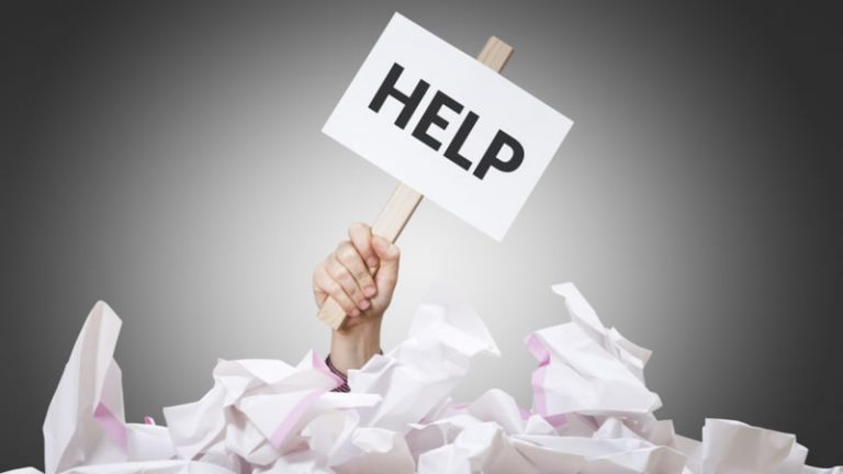 Overwhelmed entrepreneur with help sign surrounded by paperwork during Ontario business name change
