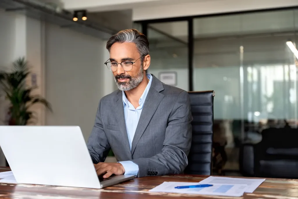 Ontario corporation owner at desk with laptop - guide to registering trade names under existing business entities