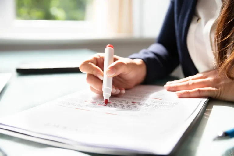 Making amendments to Ontario corporation documents - hand with red pen reviewing legal paperwork