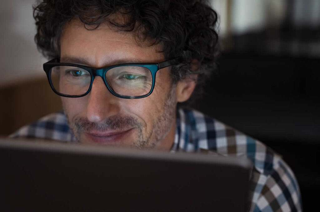 Business owner reviewing incorporation documents on laptop computer in Ontario office