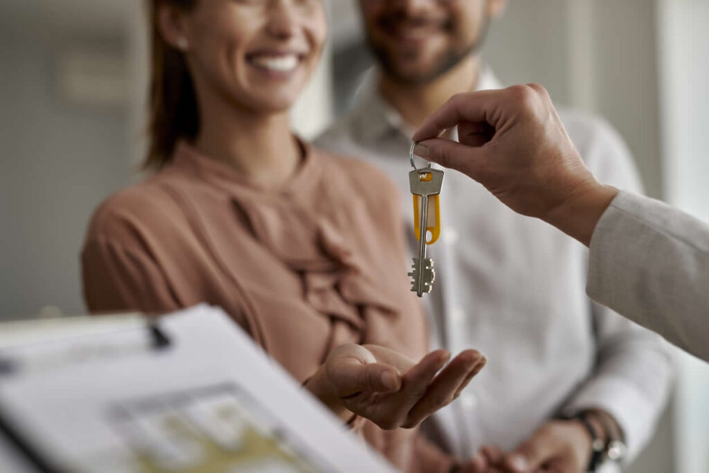 couple receiving house keys from real estate agent - incorporating rental property in Ontario