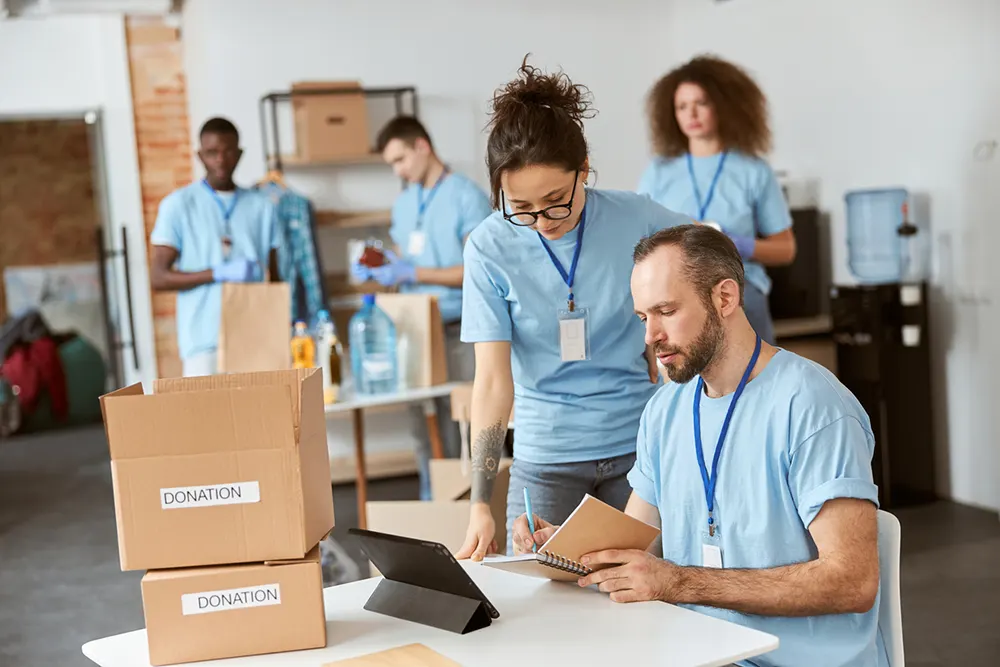 Ontario not‑for‑profit company volunteers organizing donation boxes in a community centre