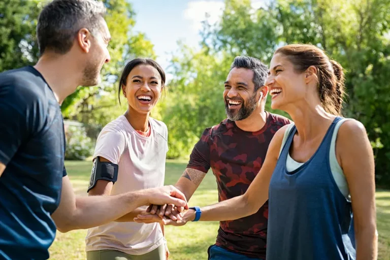 Athletic club members doing team cheer outdoors - sports community building in Ontario