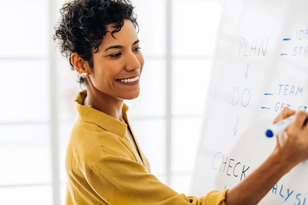 business woman writing ideas on whiteboard