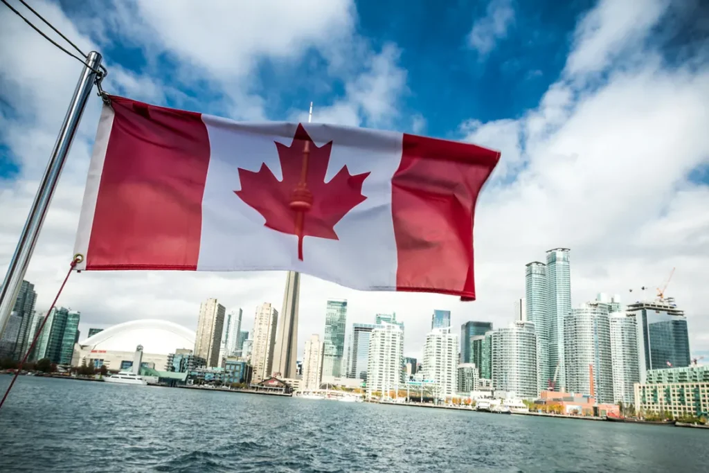 Canadian flag waving over Toronto skyline and waterfront - Ontario Business Central guide for foreigners starting business