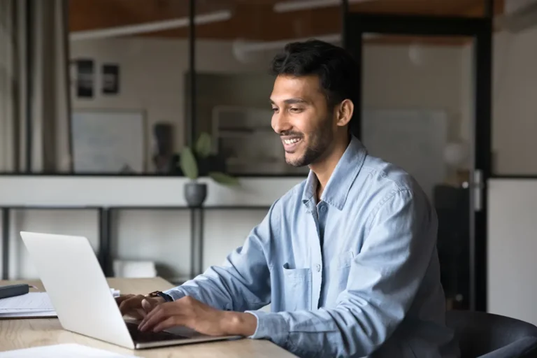 Entrepreneur searching business name availability online on laptop in modern home office in Ontario