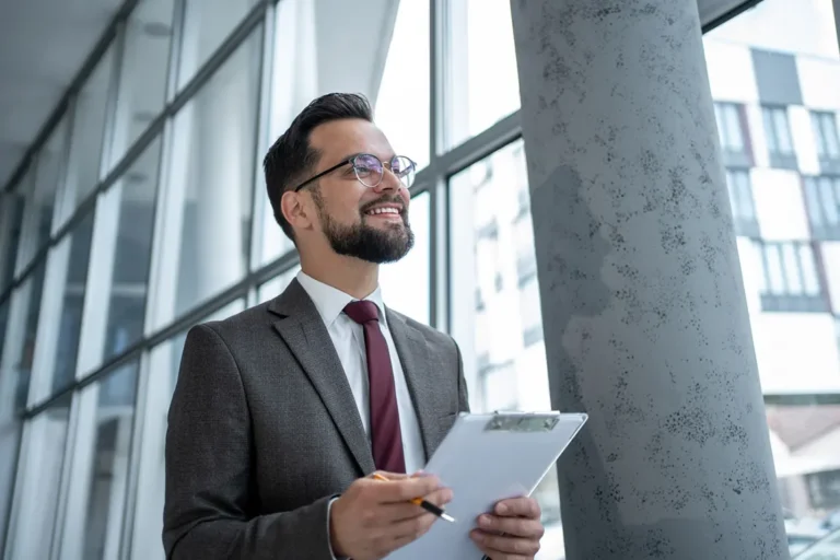 Confident entrepreneur reviewing notes about incorporating his side hustle in a modern office building.