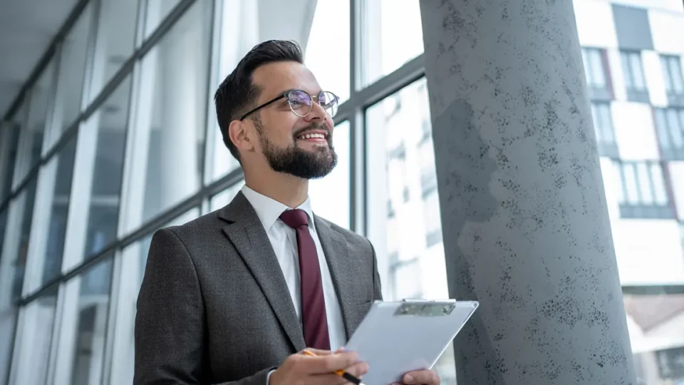 Confident entrepreneur reviewing notes about incorporating his side hustle in a modern office building.