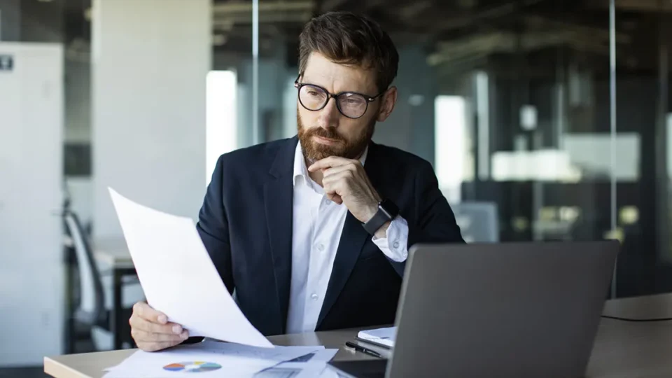 Canadian business owner reviewing corporate structure documents for multiple business ventures