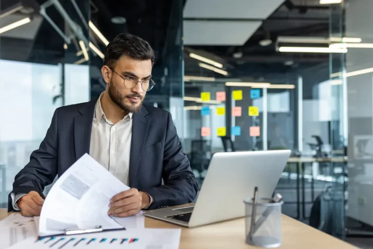Professional entrepreneur reviewing corporate documents and financial reports for holding company setup in Canada