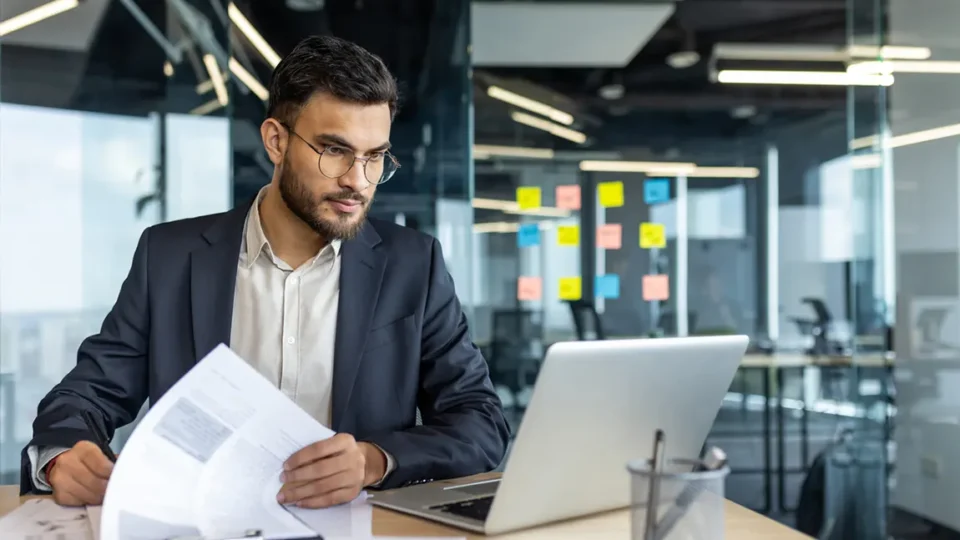 Professional entrepreneur reviewing corporate documents and financial reports for holding company setup in Canada