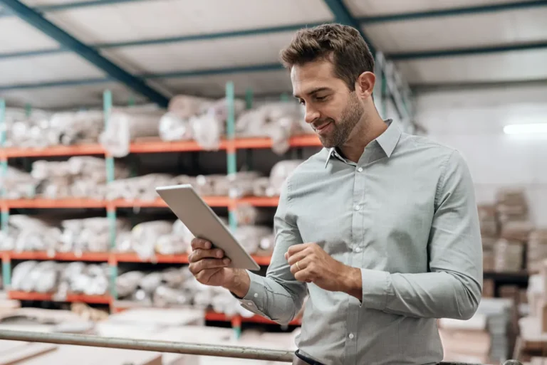 Business owner reviewing business name registration documents on tablet in warehouse for Ontario sole proprietorship