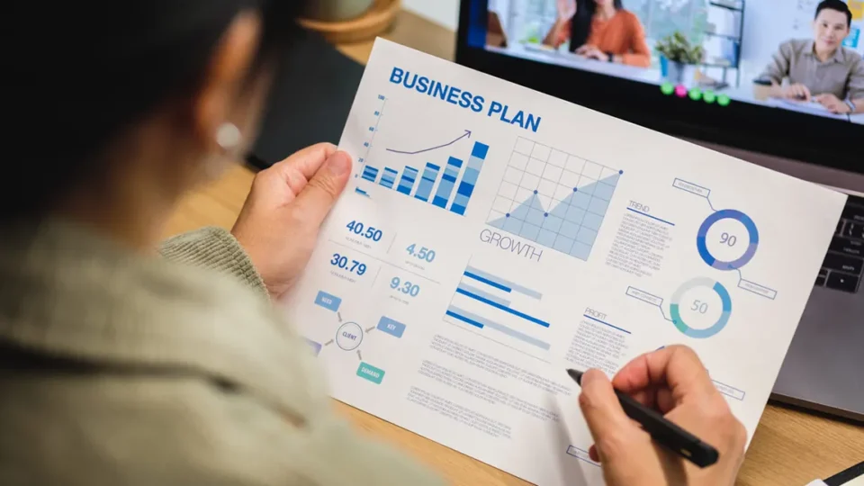 Business owner reviewing simple business plan template with financial projections and growth metrics