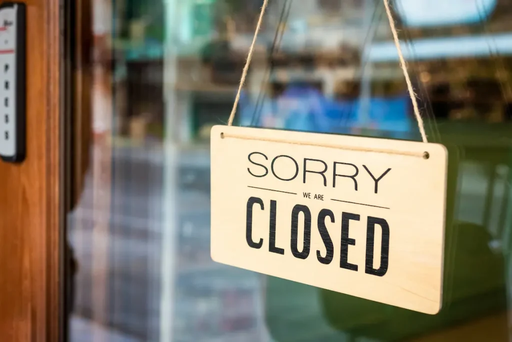 A closed business door displays a "Sorry, we're closed" sign, signaling that the establishment is currently not operating.