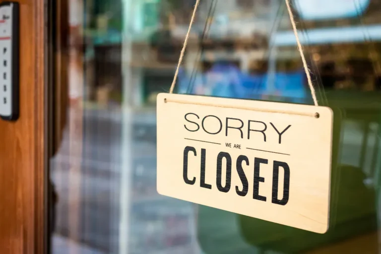 A closed business door displays a "Sorry, we're closed" sign, signaling that the establishment is currently not operating.