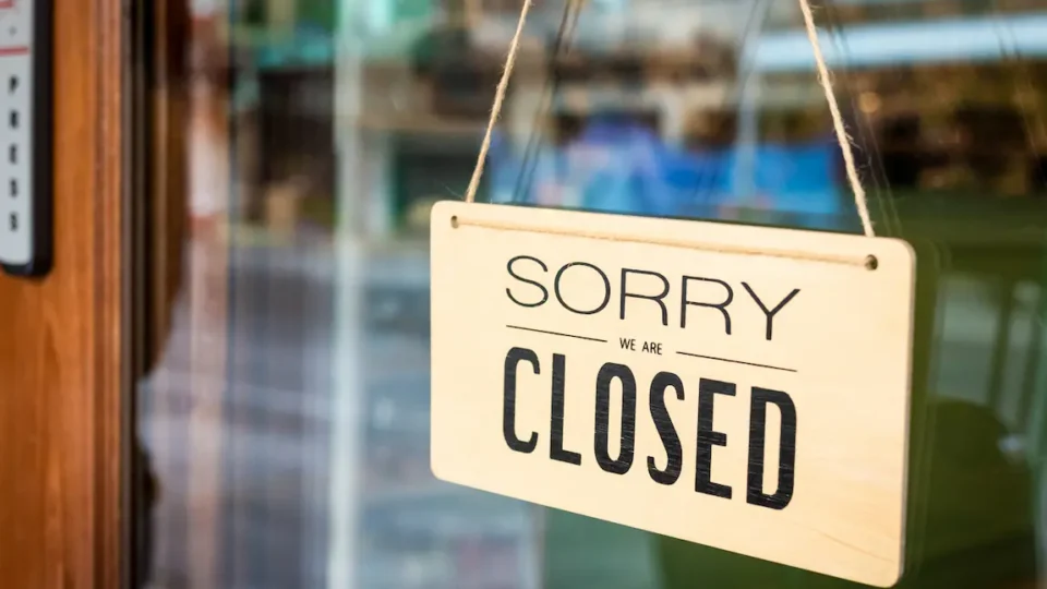 A closed business door displays a "Sorry, we're closed" sign, signaling that the establishment is currently not operating.