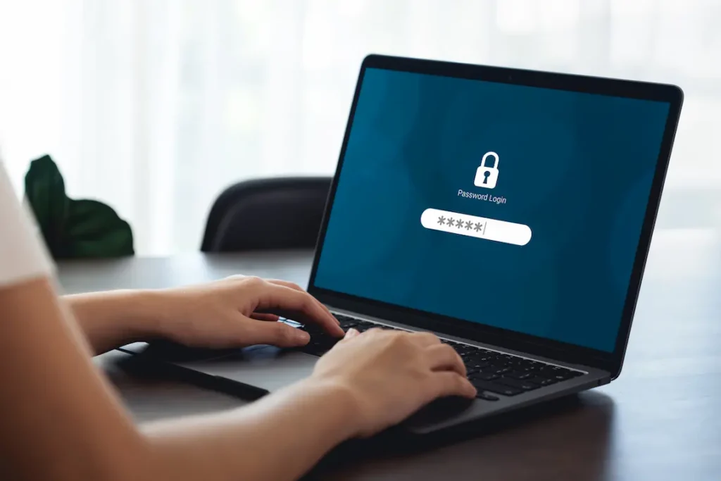 Person using a laptop to input a company key, illustrating cybersecurity measures for business protection.