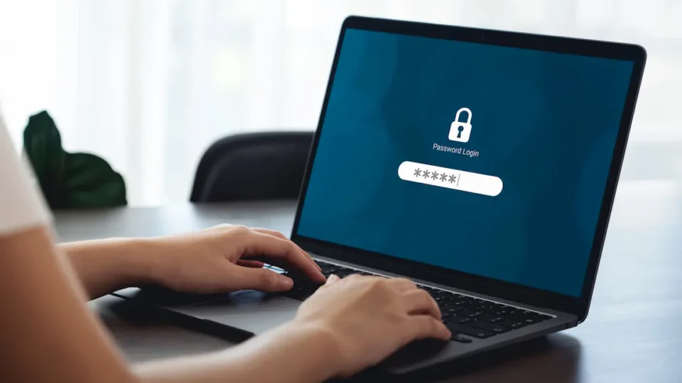 Person using a laptop to input a company key, illustrating cybersecurity measures for business protection.