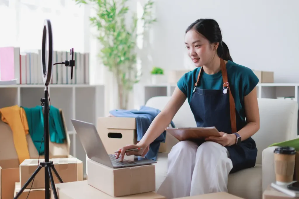 A woman on a couch uses a laptop to investigate the potential of incorporating her side business.