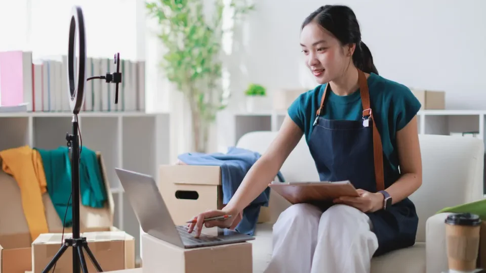 A woman on a couch uses a laptop to investigate the potential of incorporating her side business.