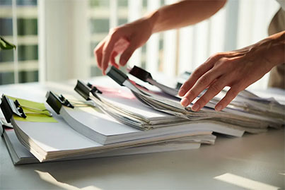 Obtain an Ontario Profile Report for a Corporation Hands sorting through corporate file folders representing an Ontario corporate profile report search